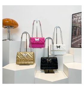 Detail of elegant quilted flap bags with butterfly clasp and metal chain straps