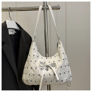 Detail of white hobo bag with rabbit pattern, ribbon bow and silver heart pendant