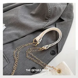 Detail des cremefarbenen Leder- und Goldkettenschultergurts für modische Handtaschen