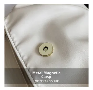 Détail d'un sac en cuir plissé blanc doté d'une boucle magnétique ronde dorée de qualité