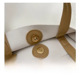 Close-up of magnetic buckle closure and double stitching on minimalist tote bag