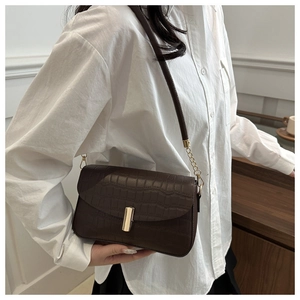 Detail of vintage brown faux crocodile leather shoulder bag with golden rectangle lock