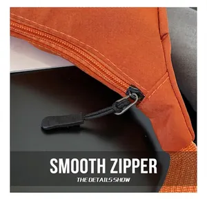 Detail view of smooth black rope zipper pulls on durable orange nylon crossbody bag
