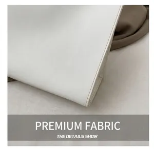 Detail showing high-quality white leather texture and neat light brown stitching on the bag