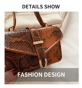 Close-up of the snakeskin texture and golden metal buckle on a brown crossbody handbag