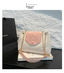 Detail der rosa-weißen Tasche mit goldener Metallkette und glänzender PU-Textur
