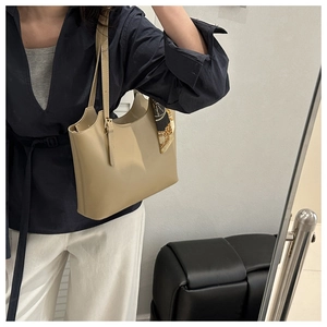 Detail of minimalist khaki tote bag featuring a vintage floral silk scarf handle decoration