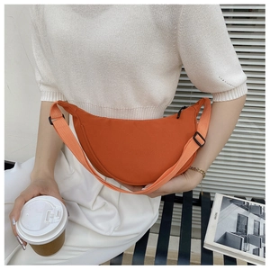 Close-up of bright orange nylon crescent bag with adjustable wide woven shoulder strap