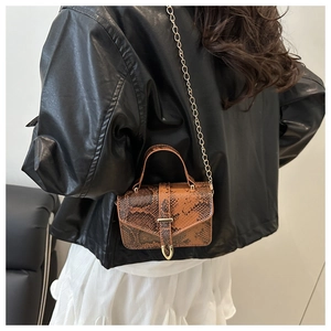 Close-up of vintage brown snakeskin mini bag with golden chain and metal clasp detail