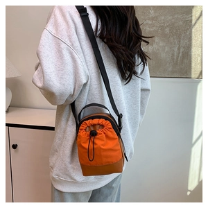 Detail einer Kordelzug-Beuteltasche aus orangefarbenem Segeltuch und Lederboden