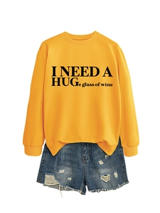 Dettaglio felpa gialla con stampa I Need A Huge Glass Of Wine e pantaloncini di jeans
