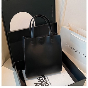 Gros plan du sac à main noir minimaliste avec une texture en cuir mat de qualité