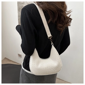 Model view of white crescent bag with crocodile texture and golden metal hardware