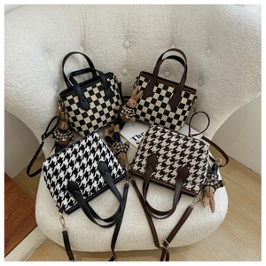 Detail of houndstooth and checkered crossbody bags with cute plush bunny charms