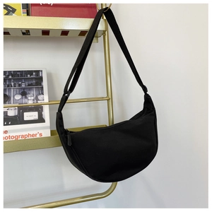 Detailed view of black nylon hobo bag featuring wide adjustable strap and metal rack