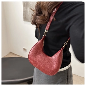 Detailed back view of a woman wearing the red woven crescent hobo shoulder bag