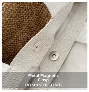 Detail of silver magnetic snap closure on a white leather and woven straw handbag