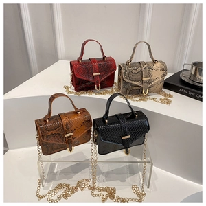 Detailed view of four textured snake skin crossbody bags with elegant gold chain straps