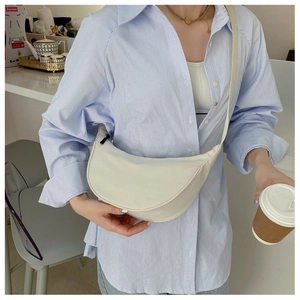 Detailed view of an adjustable strap on a white nylon crescent crossbody bag