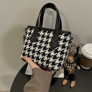 Classic black and white houndstooth tote bag with black leather handles and rabbit charm