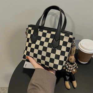 Classic black and white checkered handbag with leather handles and bunny charm