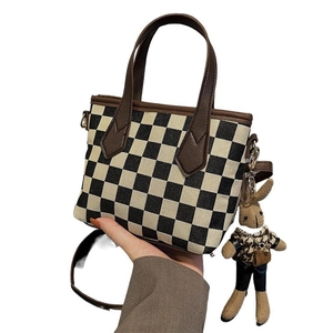 Classic houndstooth crossbody bag with brown leather handles and cute bunny pendant