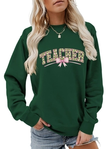 Detail of green teacher sweatshirt featuring clover patterns and a pink bow graphic