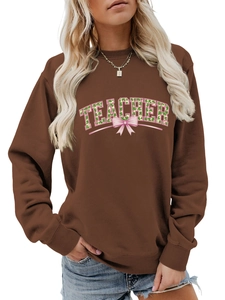 Detail of teacher letter print sweatshirt with shamrock patterns and pink bow decoration