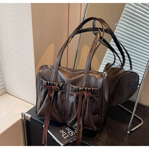 Macro detail of the dark brown retro tote bag featuring decorative bow and pleated pockets