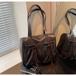 Detail of vintage coffee brown shoulder bag with pleated drawstring pockets and bow
