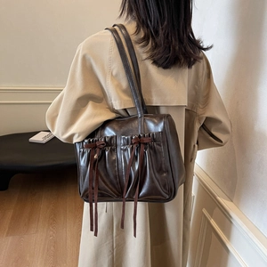 Retro coffee brown shoulder bag with bow detail worn with beige trench coat