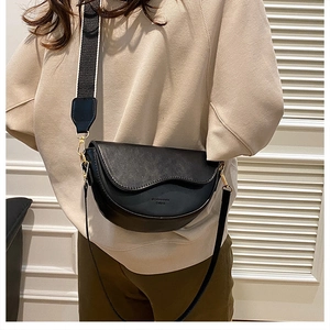 Detail of black half-moon saddle bag with contrasting wide printed fabric strap