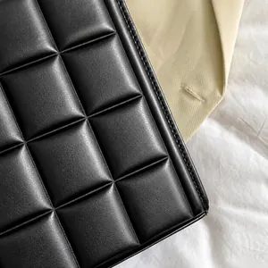 Macro detail showing the high-quality padded square quilting on this black leather tote bag