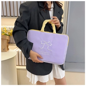 Detail of lavender laptop bag featuring butterfly embroidery and yellow ruffled handles