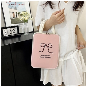 Close-up of pink laptop sleeve with red ribbon embroidery and sturdy white handles