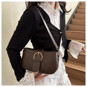 Détail du sac porté épaule marron foncé vintage avec boucle fer à cheval dorée