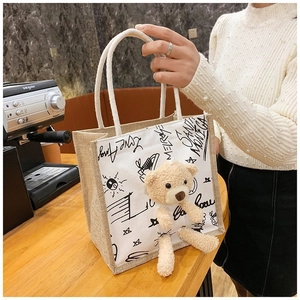 Detail of linen tote bag featuring a 3D plush bear and starry moon graffiti patterns