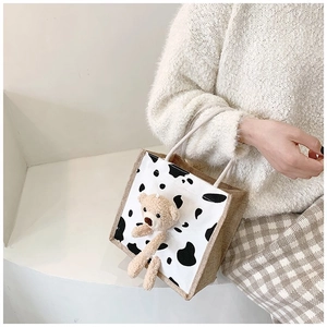 Close-up of cute 3D teddy bear on cow print jute tote bag with durable handles