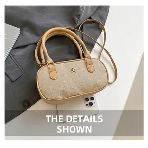 Detail of woven pillow bag with leather trim, metal logo and smartphone for size comparison
