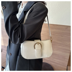 Détail du sac à bandoulière en cuir crème avec boucle vintage et sangle réglable