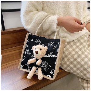 Detail of canvas tote bag featuring a cute 3D plush bear and artistic graffiti print