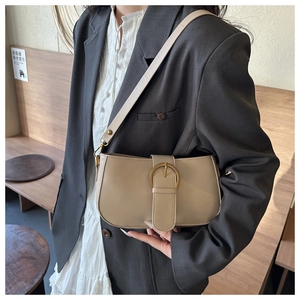 Détail d'un sac porté épaule demi-lune beige avec boucle dorée élégante sur un mannequin