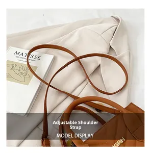 Close-up of brown quilted handbag with adjustable strap and gold metal brand logo plate