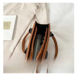 Top view of brown leather handbag interior showing large capacity and cylindrical tumbler