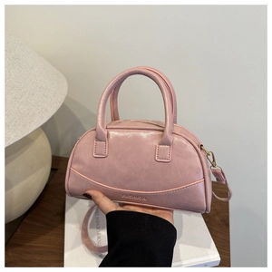 Pink Boston style handbag with embossed fashion text and adjustable shoulder strap detail