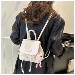 Detailed back view of a minimalist cream-white mini backpack with plush charm and pautor logo
