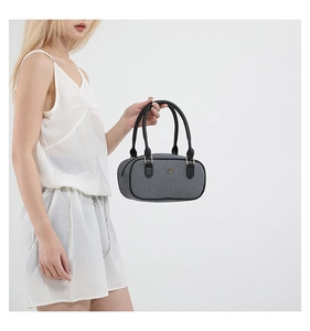 Detail of grey woven texture shoulder bag with black handles and golden metal logo hardware