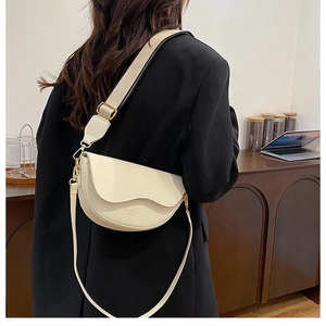 Retro cream saddle bag with wavy flap and adjustable dual straps shown on a model