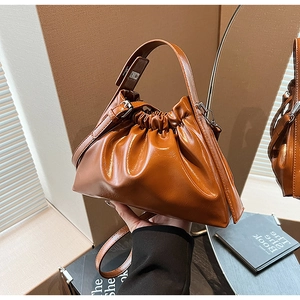Détail du sac à main nuage plissé caramel en cuir brillant avec bandoulière et chaîne