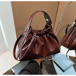 Détail du sac à main en cuir verni bordeaux avec design plissé en forme de nuage